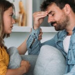 Man and woman sitting on sofa and man looking thoughtful as symbol for dating after divorce