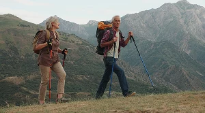 A couple hiking with backpacks and running poles. (Generated with AI)