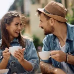 A couple drinking a cup of cofee together in the public.