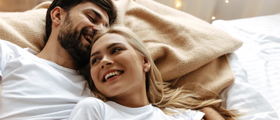 A couple cuddling in the bed.
